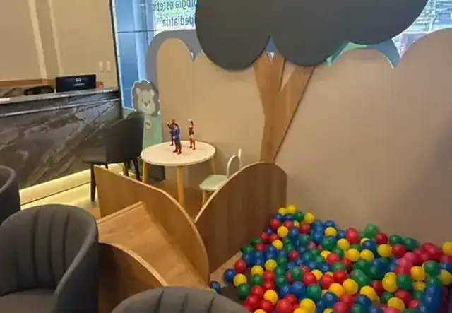 Área infantil com piscina de bolinhas coloridas e árvore decorativa