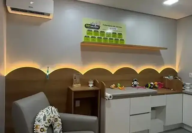 Sala de vacinação infantil com poltrona acolhedora, brinquedos e calendário na parede